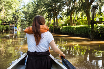 A woman in a life jacket canoes on the Tigre River delta in Buenos Aires, Argentina