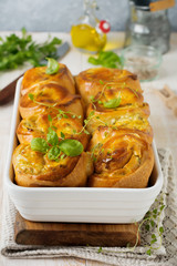 Buns with feta cheese and basil of yeast dough on a light wooden background. Selective focus. Rustic style.