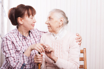 Care of senior woman at home sitting on the couch