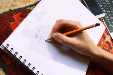 young woman doint lettering with pencil in hand