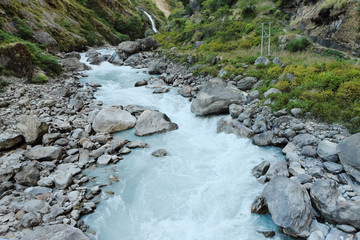 Rapids and waterfall in the narrow place of the mountain river