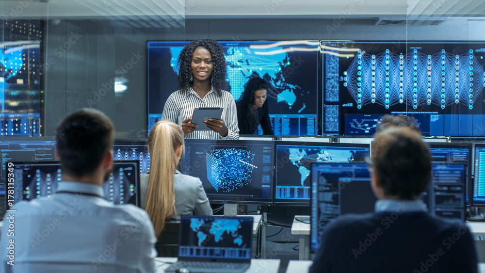 Poster Chief Project Engineer Consults Tablet Computer and Holds Briefing for a Team of Scientists that are Building Machine Learning System. Displays Show Working Model of Neural Network.