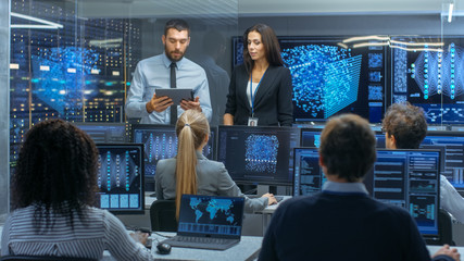 Head of the Department and Project Manager Discuss Work Process Using Data on Tablet Computer....