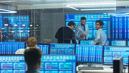 Three Experienced Stock Traders Talking Business, Consulting Documents and Argue About Data. They...