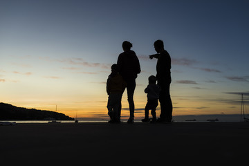 Silhouetted family outdoors looking at the sunset