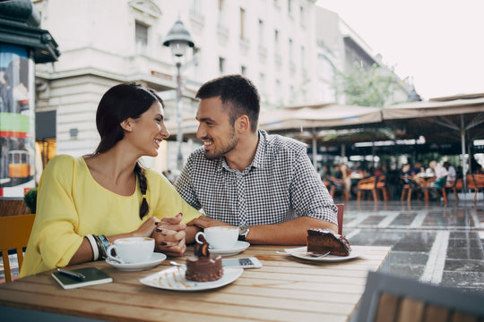 Smiling Couple in Love Sitting at a Cafe