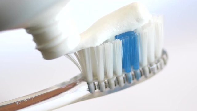Angle macro shot of toothpaste applied to toothbrush