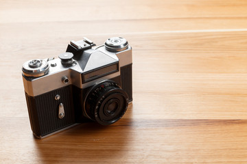 Old retro camera on wooden table background