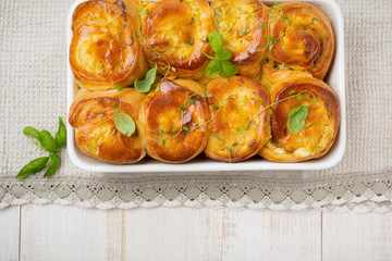 Buns with feta cheese and basil of yeast dough on a light wooden background. Selective focus. Rustic style.Top view.