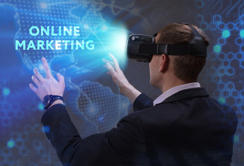 Business, Technology, Internet and network concept. Young businessman working in virtual reality glasses sees the inscription: Online marketing