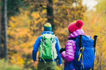 Man and woman happy couple hikers walking in autumn woods