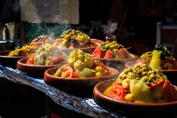 Fotobehang A lot of warm tagines with delicious vegetables on a market © pwollinga