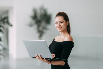 beautiful business lady at work with a laptop and phone sitting in the office