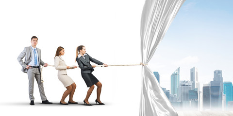 Young businesspeople working in collaboration and pulling white advertisement banner