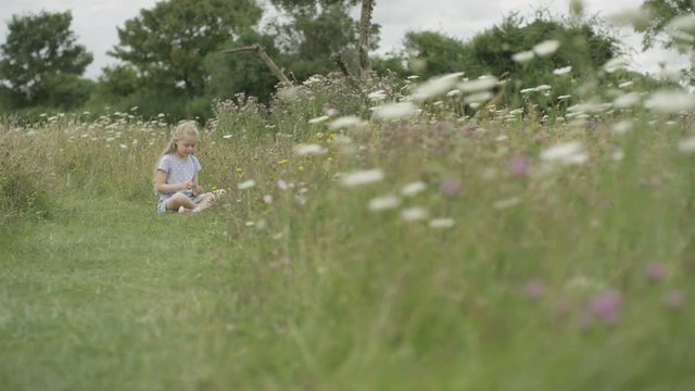  Little girl playing alone in the countryside on a summer day