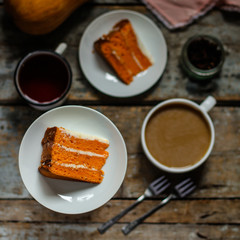 piece of orange cake on a white plate on a wooden table