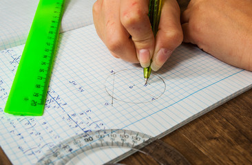 schoolgirl solves the problem of mathematics. school, education, people and learning concept - close up of student or woman hands with ruler and pencil drawing line in notebook