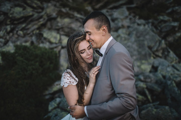 Fototapeta premium Romantic couple standing together holding hands in the mountains