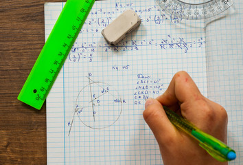 schoolgirl solves the problem of mathematics. school, education, people and learning concept - close up of student or woman hands with ruler and pencil drawing line in notebook