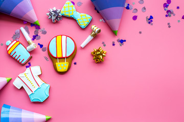 Cook gingerbread cookies with ticker tape for baby shower on pink background top view mockup