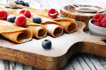 Fototapeta na wymiar Delicious Tasty Homemade crepes or pancakes with raspberries and blueberries