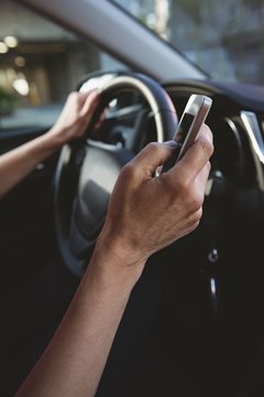 Person using mobile phone while driving car