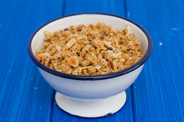 granola with nuts in the bowl on wooden background