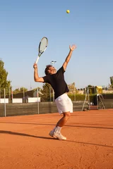 Foto op Plexiglas Professional player doing a tennis kick on court in the afternoon.  © pablobenii