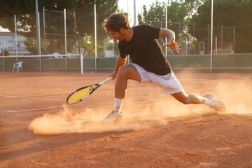 Tuinposter Professional tennis player man playing on court in afternoon.   © pablobenii