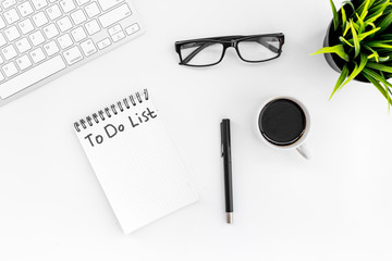 To do list for businessman in notebook on office table. White background top view