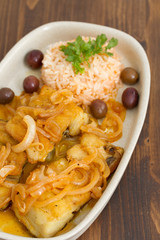 fried codfish with boiled rice and olive oil on dish