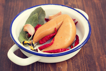 smoke sausage on white dish on wooden background