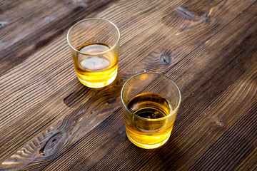 Glasses of whiskey on rustic wooden background