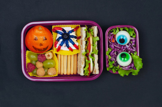 Halloween lunch box with school lunch on black background
