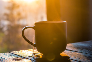 Still life with cup of coffee on the carpathian mountains background during the sunset