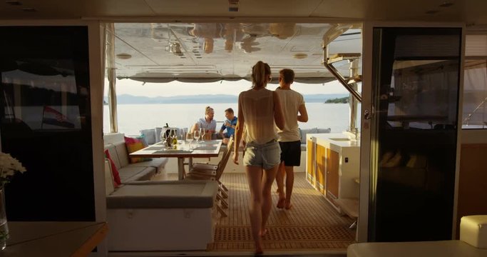 Group of Successful Young People Join Others in the Stern of the Yacht with Cocktails. In the Background Calm Sea and Islands. Shot on RED Epic 4K UHD Camera.