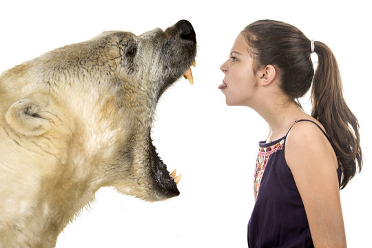 Young fearless girl with a polar bear on a white background