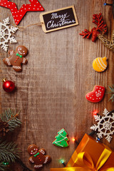 Obraz na płótnie Canvas Beautiful Christmas background with gingerbreads, sweets and gift on wooden background. Merry Christmas postcard 2018