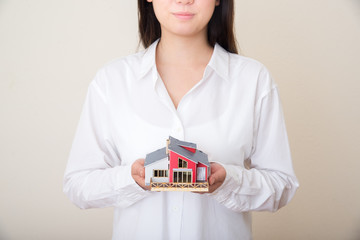 young asian woman with miniture house