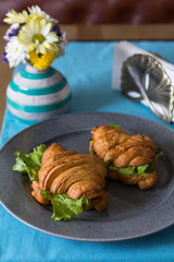 Croissant sandwich with ham on grey plate
