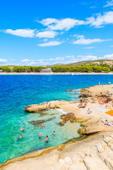 PRIMOSTEN TOWN, CROATIA - SEP 5, 2017: People swimming in sea on small beach with turquoise water in Primosten town, Dalmatia, Croatia.