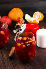 Christmas hot drink with citruses and spices - mulled wine on a wooden background