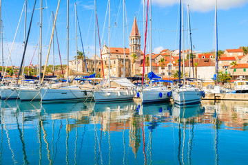 Reflection of sailing boats anchoring in beautiful Milna port with church tower in background, Brac...