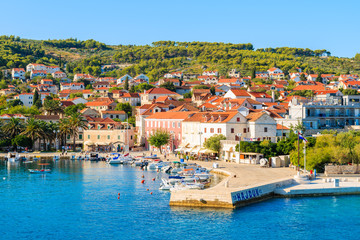 Fototapeta na wymiar SUPETAR PORT, CROATIA - SEP 15, 2017: View of Supetar port with colorful houses and boats, Brac island, Croatia.