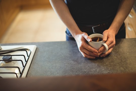 Mid section of man having black coffee