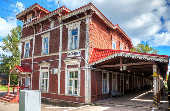 Old wooden provincial railway station with platform in summer sunny day. Novgorod region, Russia