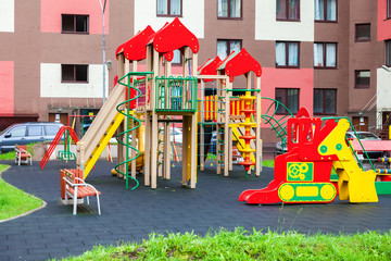 Fototapeta na wymiar Colorful сhildren's playground for kids in new district with many slides, swings, toys for play