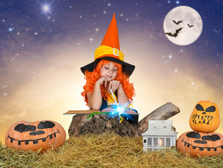 Halloween.The little witch,the child reads the spell in the sorcerer book.	