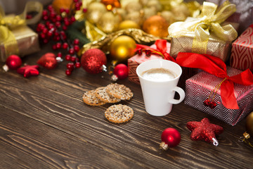 Christmas card. Christmas gift, cup of coffee and decorations on wood background. Christmas lifestyle concept. .