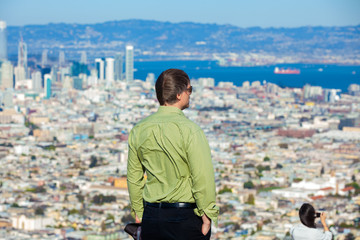 Fototapeta na wymiar Caucasian man viewing San Francisco from top of Twin Peaks